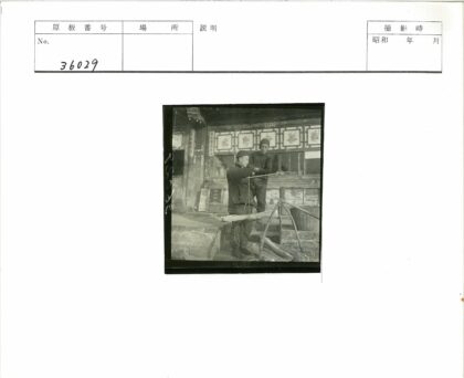 两名男子与称秤装饰墙建筑前.jpg