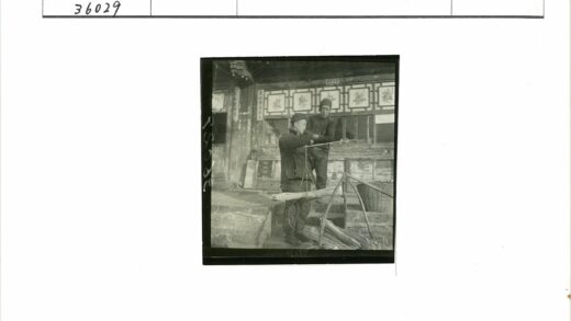 两名男子与称秤装饰墙建筑前.jpg