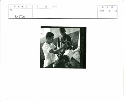 两男子照料受伤绷带狗.jpg