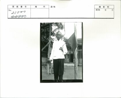 举旗者站在树木与建筑前.jpg