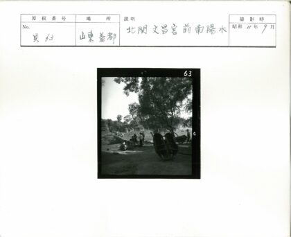 乡村土路旁的独轮车与树景.jpg