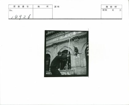 人与猴子竹竿互动古建筑前.jpg
