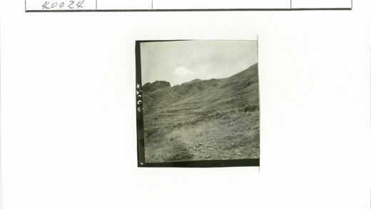 人群攀登多云天空下陡峭草坡.jpg