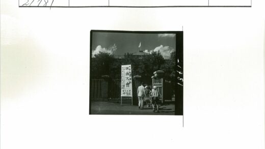 人群穿过大门走向旗帜建筑.jpg