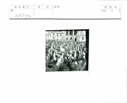 人群聚集宏伟建筑前举手戴帽.jpg