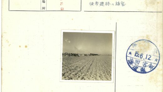 人群行走在贫瘠田野远处有建筑.jpg