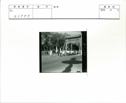 传统大门下举旗队伍行进.jpg