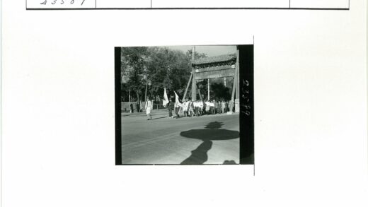 传统大门下举旗队伍行进.jpg