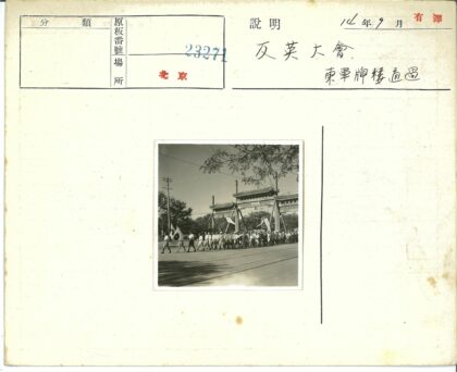 传统大门前游行人群旗帜飘扬.jpg