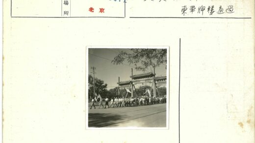 传统大门前游行人群旗帜飘扬.jpg
