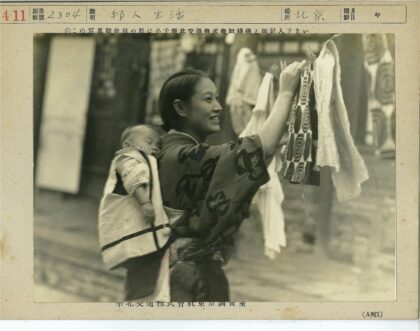 传统妇女背婴晾衣户外.jpg