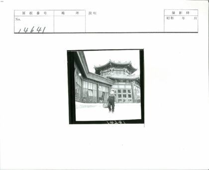 传统建筑前戴帽背包的小孩.jpg