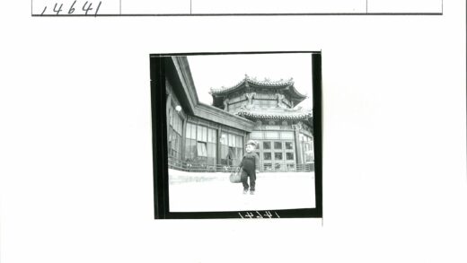 传统建筑前戴帽背包的小孩.jpg
