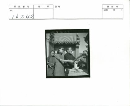 传统建筑前手持香烛的人群.jpg