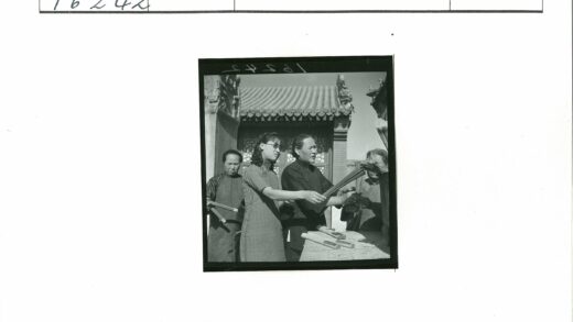 传统建筑前手持香烛的人群.jpg