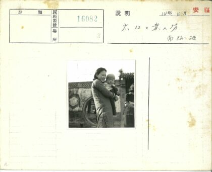 传统建筑前抱婴儿的妇女.jpg