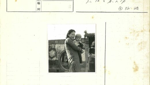 传统建筑前抱婴儿的妇女.jpg