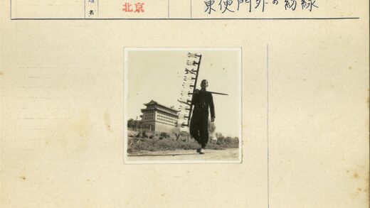 传统建筑前持拨浪鼓的人.jpg