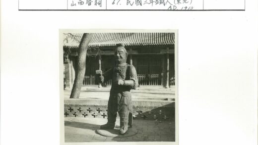 传统建筑前武士雕像与枯树.jpg