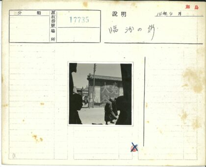 传统建筑前行人走过汉字横幅.jpg