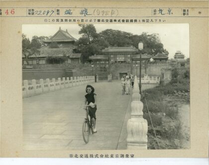传统建筑前骑自行车的妇女.jpg