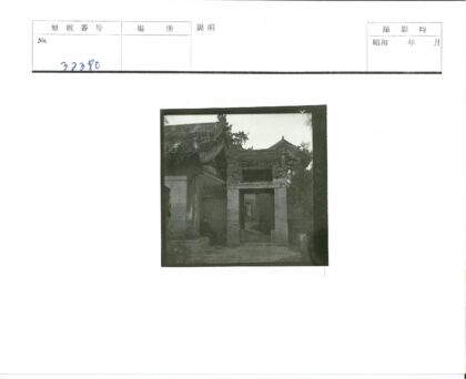 传统建筑大门旁男子坐姿.jpg