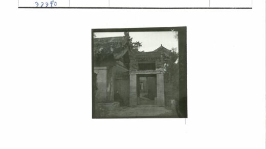 传统建筑大门旁男子坐姿.jpg