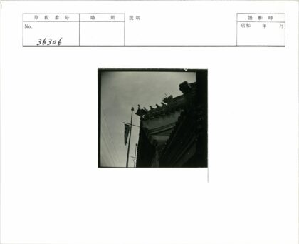 传统建筑屋顶雕刻细节与旗杆横幅.jpg
