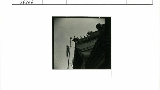 传统建筑屋顶雕刻细节与旗杆横幅.jpg