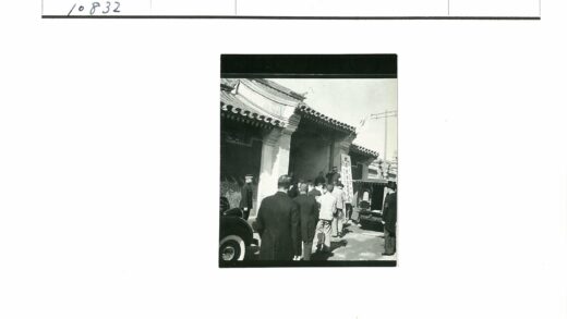 传统建筑旁军民与车辆场景.jpg