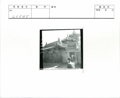传统建筑雕刻装饰与戴帽行人.jpg
