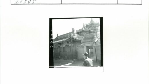 传统建筑雕刻装饰与戴帽行人.jpg