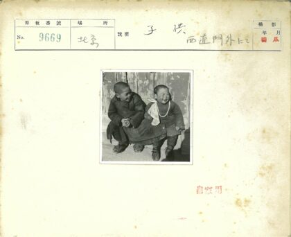 传统服装小孩微笑木墙前.jpg