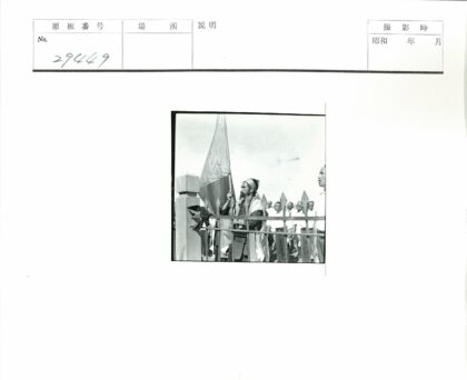 传统服装持旗者被制服人群包围.jpg