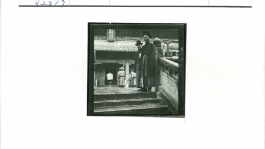 传统服装男子与仪仗队建筑前.jpg