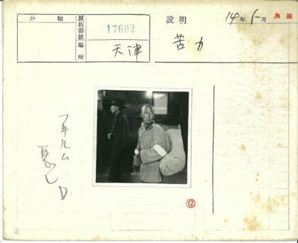传统服装男子扛包袱路人经过.jpg