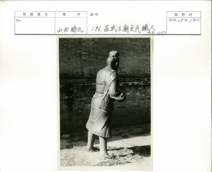 传统服装雕像倚砖墙.jpg