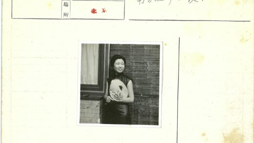 传统服饰妇女执扇窗边.jpg