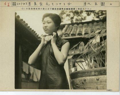 传统服饰妇女整理衣领盆栽背景.jpg
