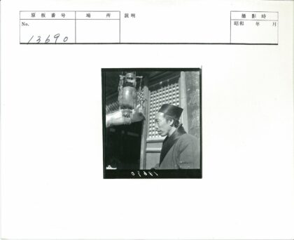传统服饰男子与古建筑格子窗前.jpg