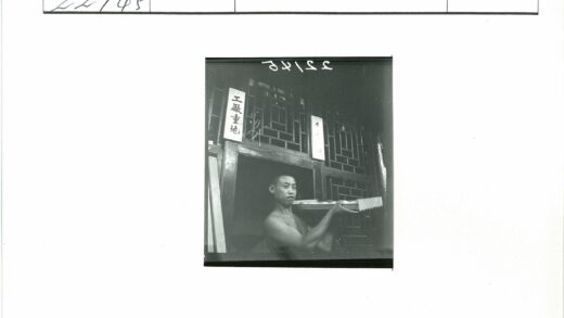 传统木建筑前男子持木托盘.jpg