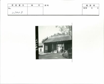 传统瓦顶大门行人穿过树林背景.jpg