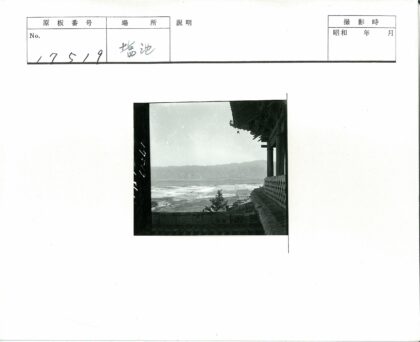 传统瓦顶木柱建筑与田野山景.jpg