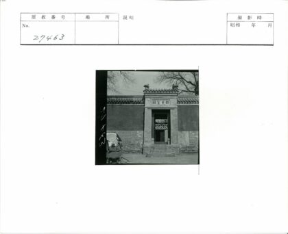 传统砖砌建筑前老人与雕刻招牌.jpg