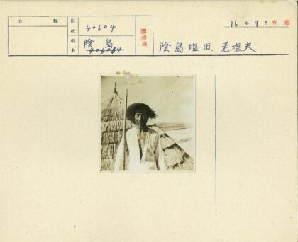 传统草帽男子站在茅草屋前.jpg
