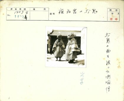 传统面具服饰与倾斜屋顶建筑.jpg