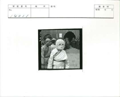 传统面具表演与古建筑前的人群.jpg