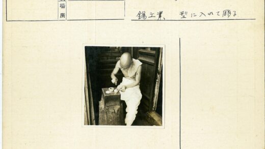光头男子坐木凳摆弄物件.jpg