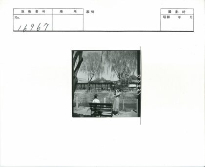 公园长凳旁人物与建筑风景.jpg