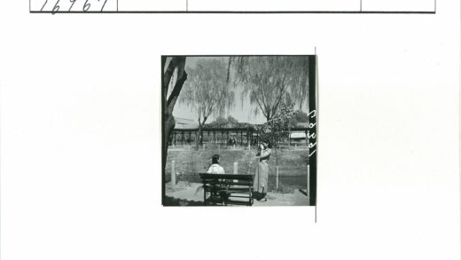 公园长凳旁人物与建筑风景.jpg